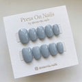Short oval-shaped slate blue press-on nail set with a high-gloss finish