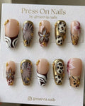 Long coffin-shaped press-on nail set with 3D floral art, metallic gold frames, and leopard animal print.