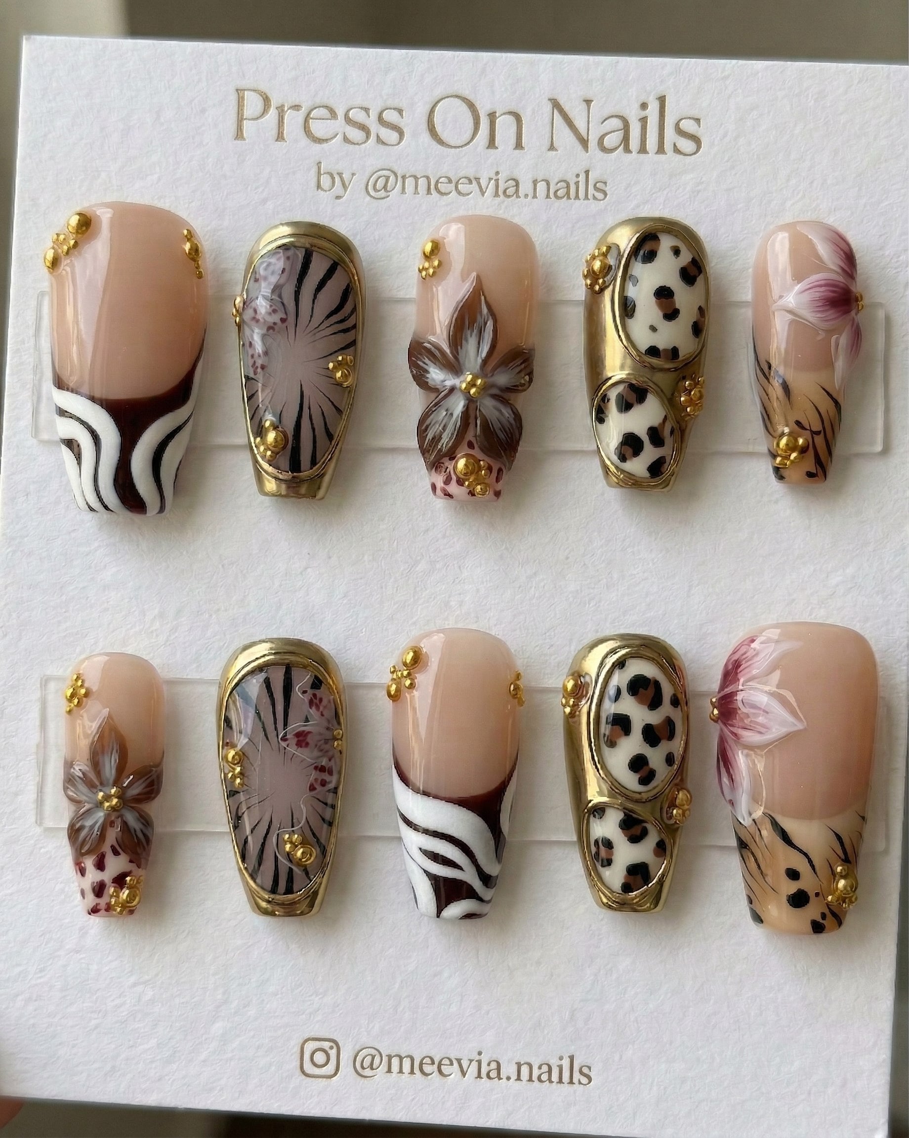 Long coffin-shaped press-on nail set with 3D floral art, metallic gold frames, and leopard animal print.