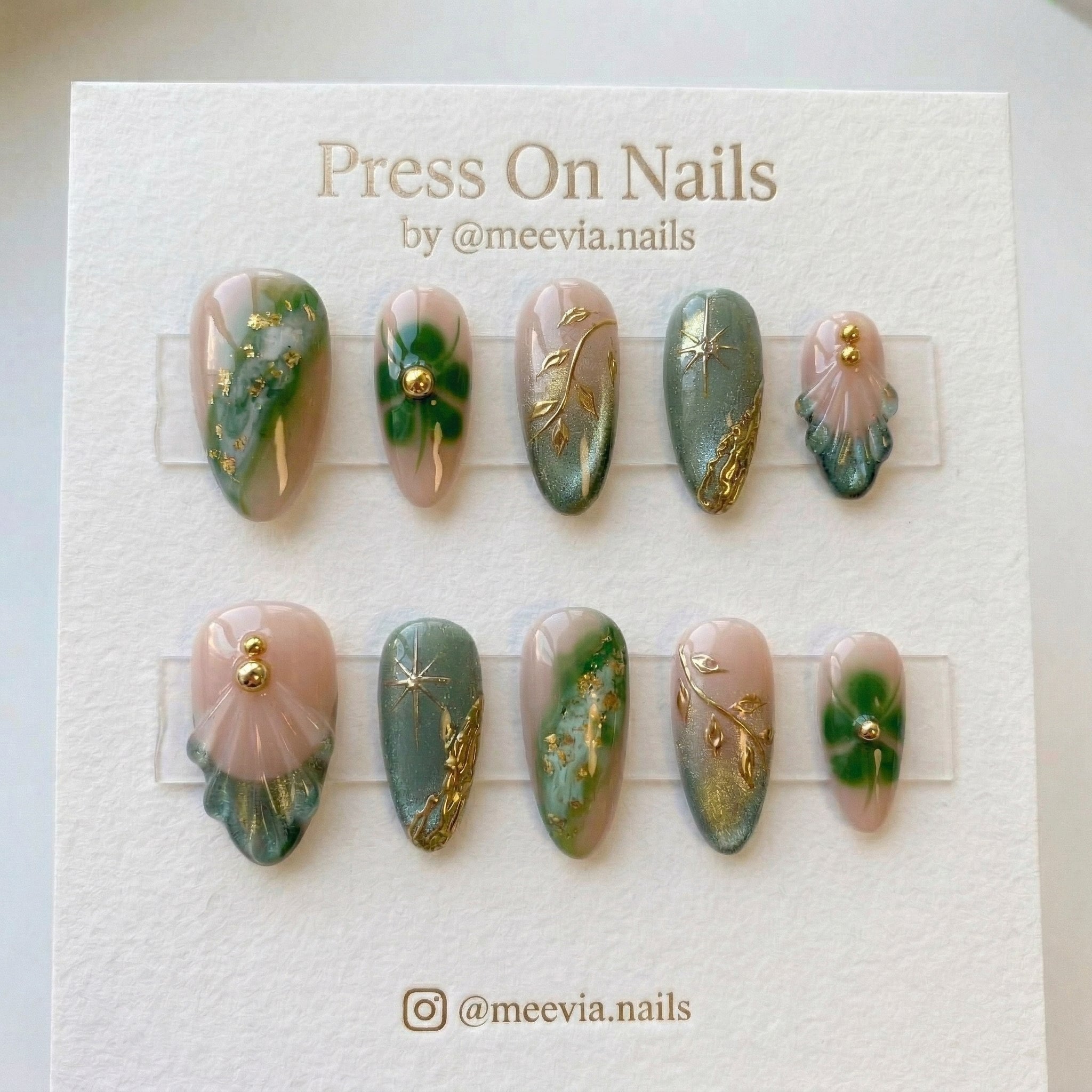 Almond-shaped sage green and nude press-on nail set with 3D gold vines and marble nail art.