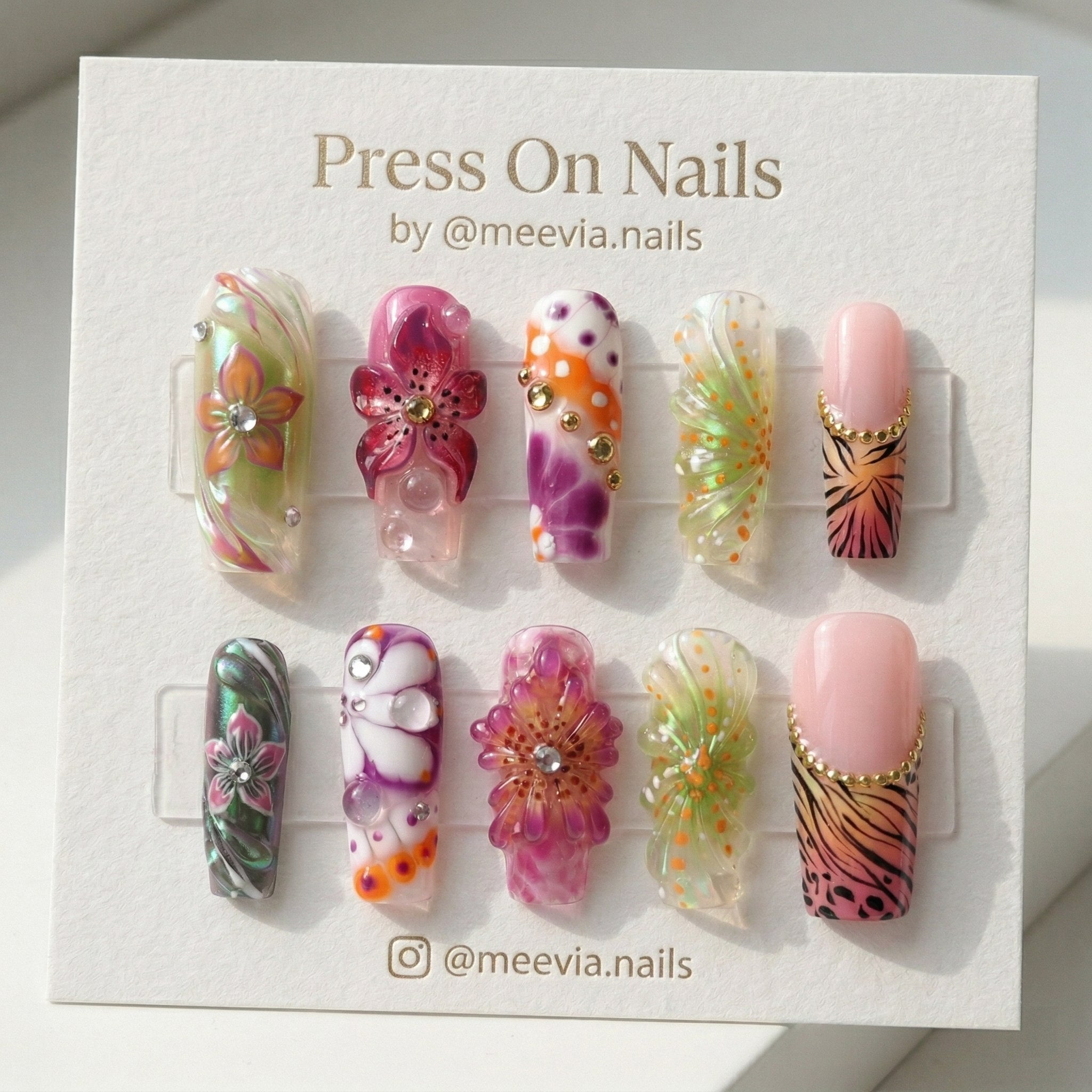 Long square press-on nail set with 3D floral designs, tiger print, and iridescent finishes.