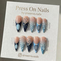 Stiletto-shaped blue press-on nail set with 3D butterfly motifs and textured shell designs