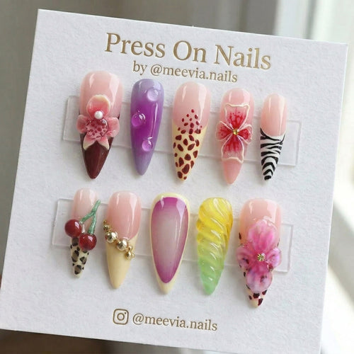 Stiletto-shaped press-on nails with 3D flowers, animal prints, and jelly droplets in a colorful artistic nail set.