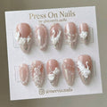Almond-shaped pink shimmer press-on nails with 3D swan, roses, and pearl accents