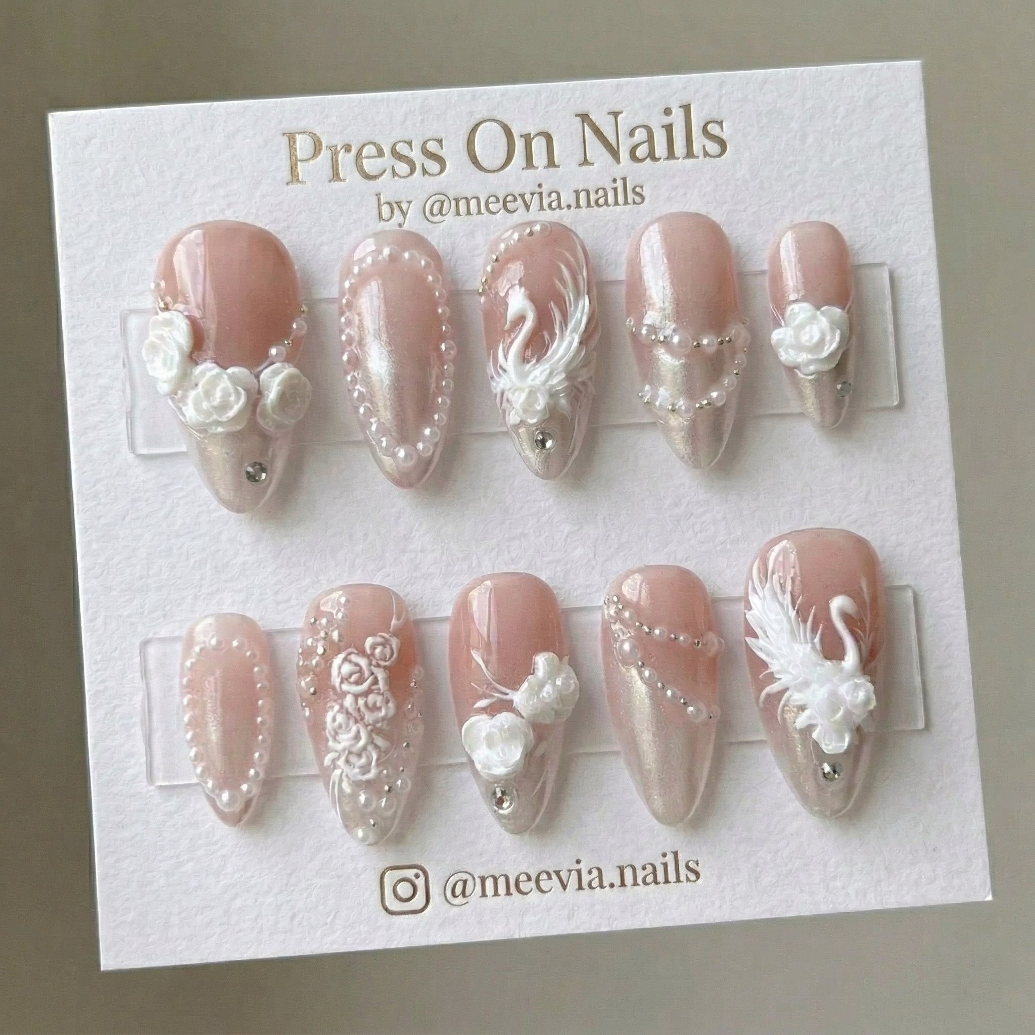 Almond-shaped pink shimmer press-on nails with 3D swan, roses, and pearl accents
