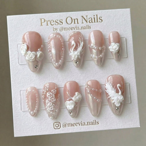 Almond-shaped pink shimmer press-on nails with 3D swan, roses, and pearl accents