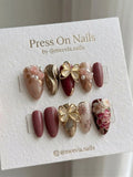 Almond-shaped burgundy and gold press-on nail set with 3D butterfly and rose motifs