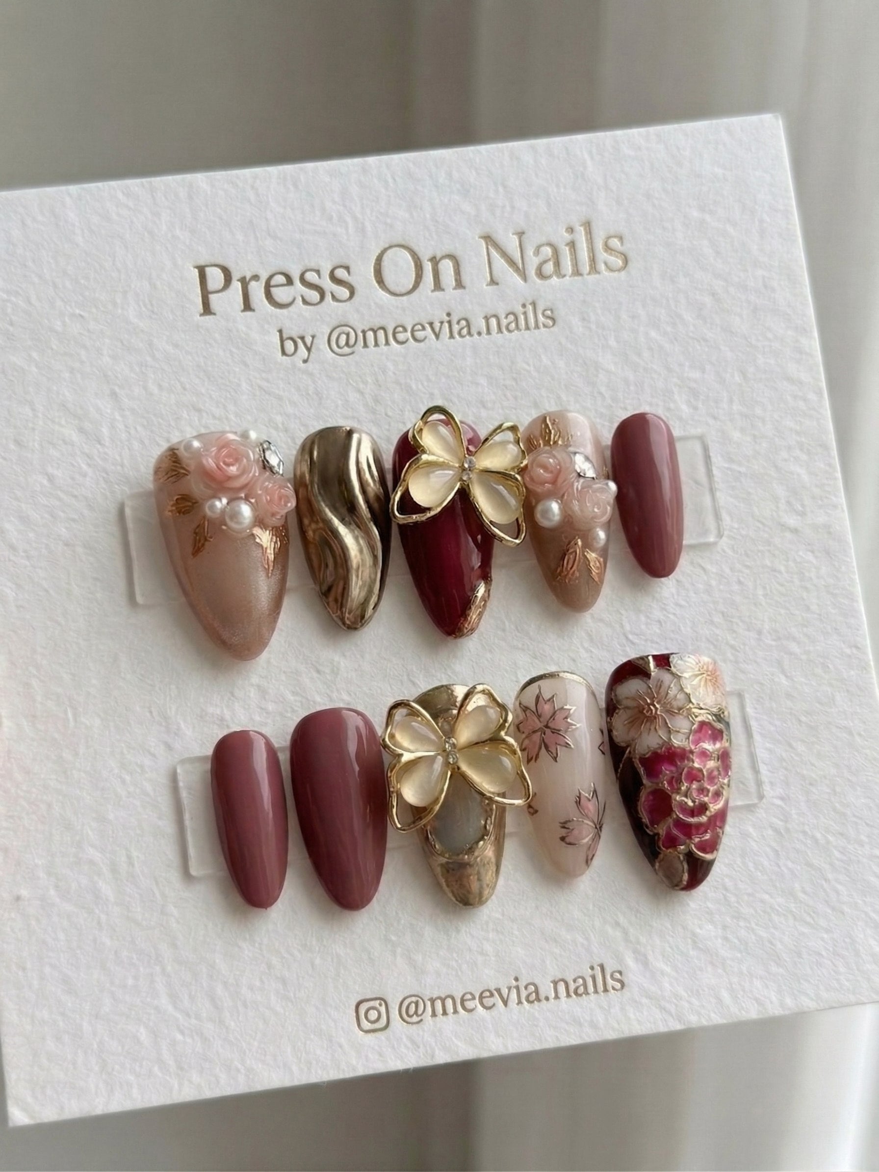 Almond-shaped burgundy and gold press-on nail set with 3D butterfly and rose motifs