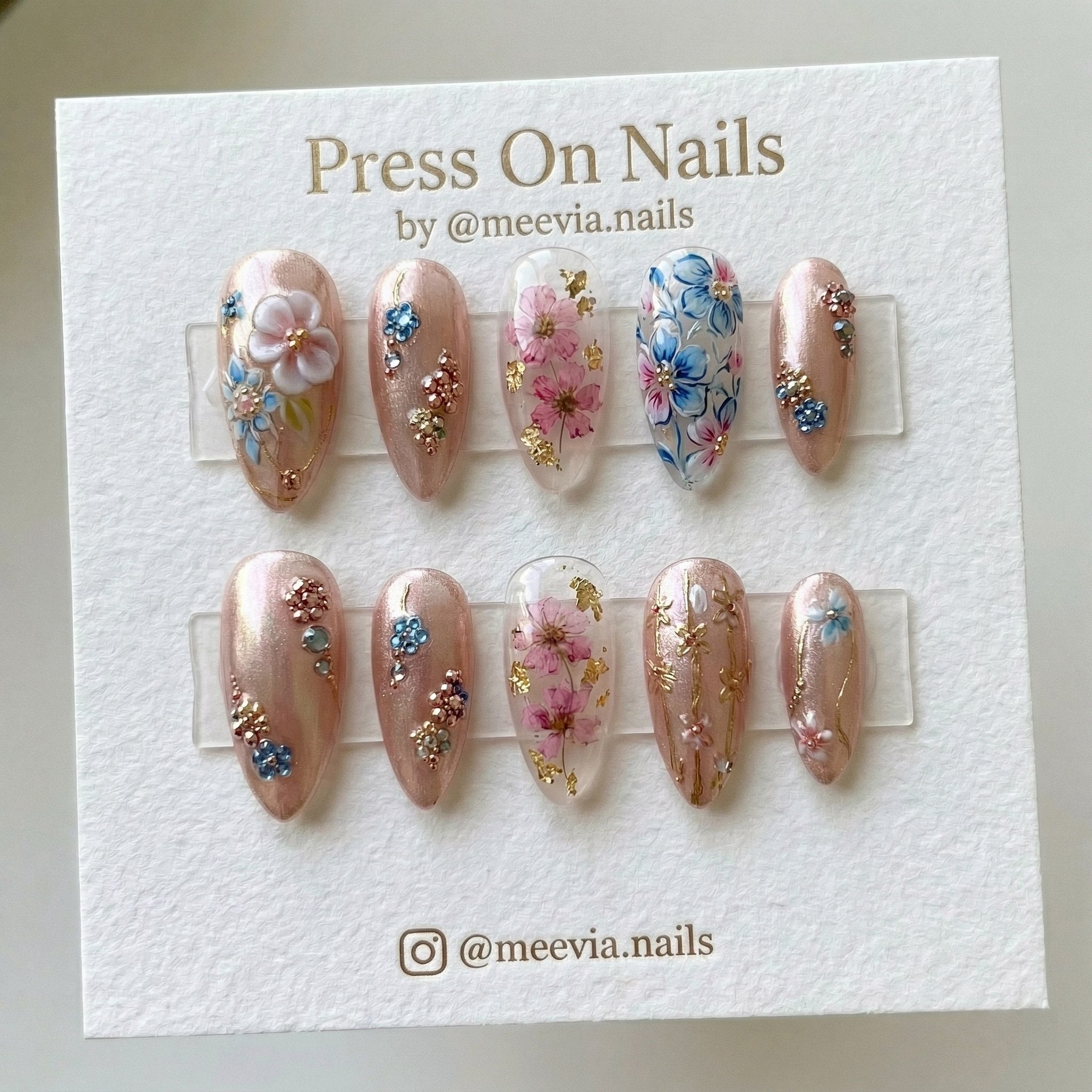Almond-shaped rose gold press-on nail set with 3D floral art and dried flowers