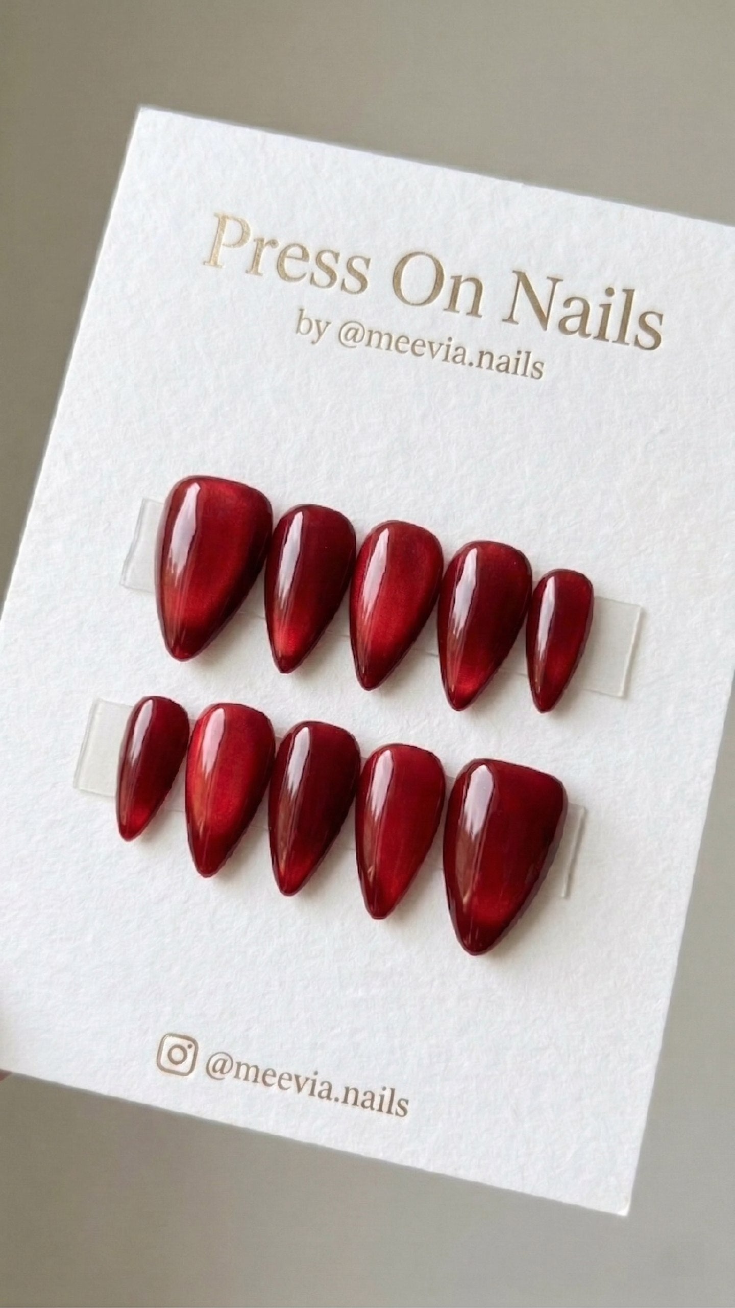 Almond-shaped deep red shimmer press-on nail set with a galaxy effect