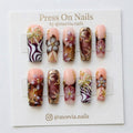 Long square press on nails with 3D pearl bows, floral art, and metallic accents