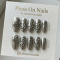 Almond-shaped silver chrome press-on nails with 3D star and butterfly designs