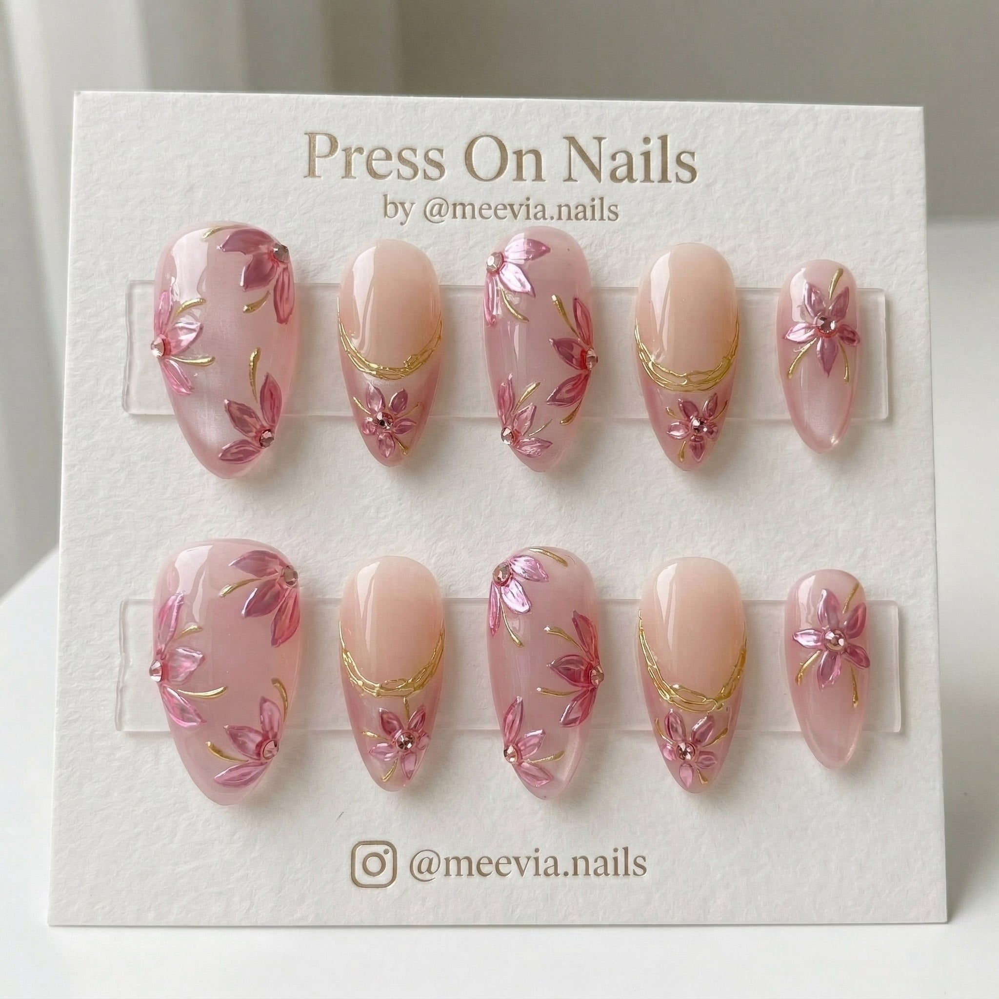 Almond-shaped pink press on nails with 3D floral art and gold metallic swirls