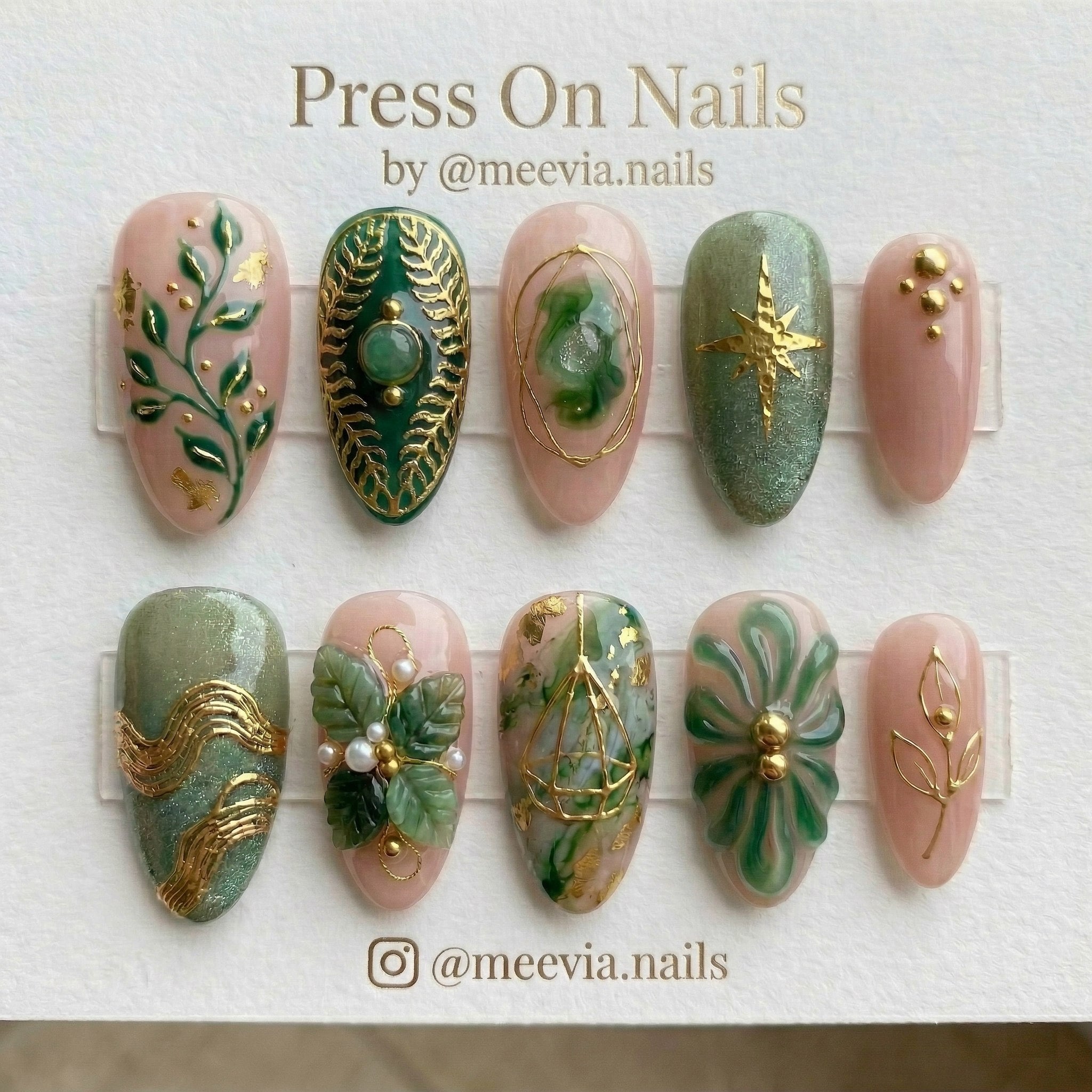 Almond-shaped press-on nail set with 3D botanical leaves, gold stars, and sage green shimmer finish
