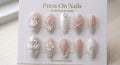 Almond-shaped 3D swan and pearl press-on nail set with white floral art and silver shimmer