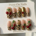 Long square leopard print press-on nails with 3D red cherries and gold vine accents