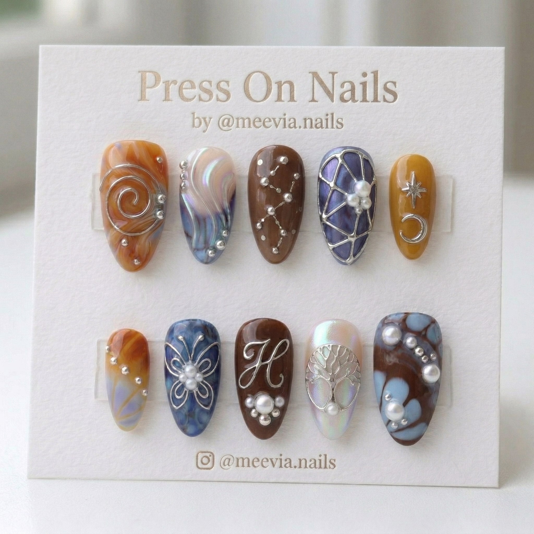 Almond-shaped press on nails with 3D silver wire art, celestial stars, and earthy marble patterns.