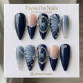 Stiletto-shaped navy blue celestial press on nails with pearls, stars, and 3D shell textures