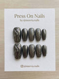 Coffin-shaped dark metallic press-on nail set with 3D molten waves and textured chrome finish