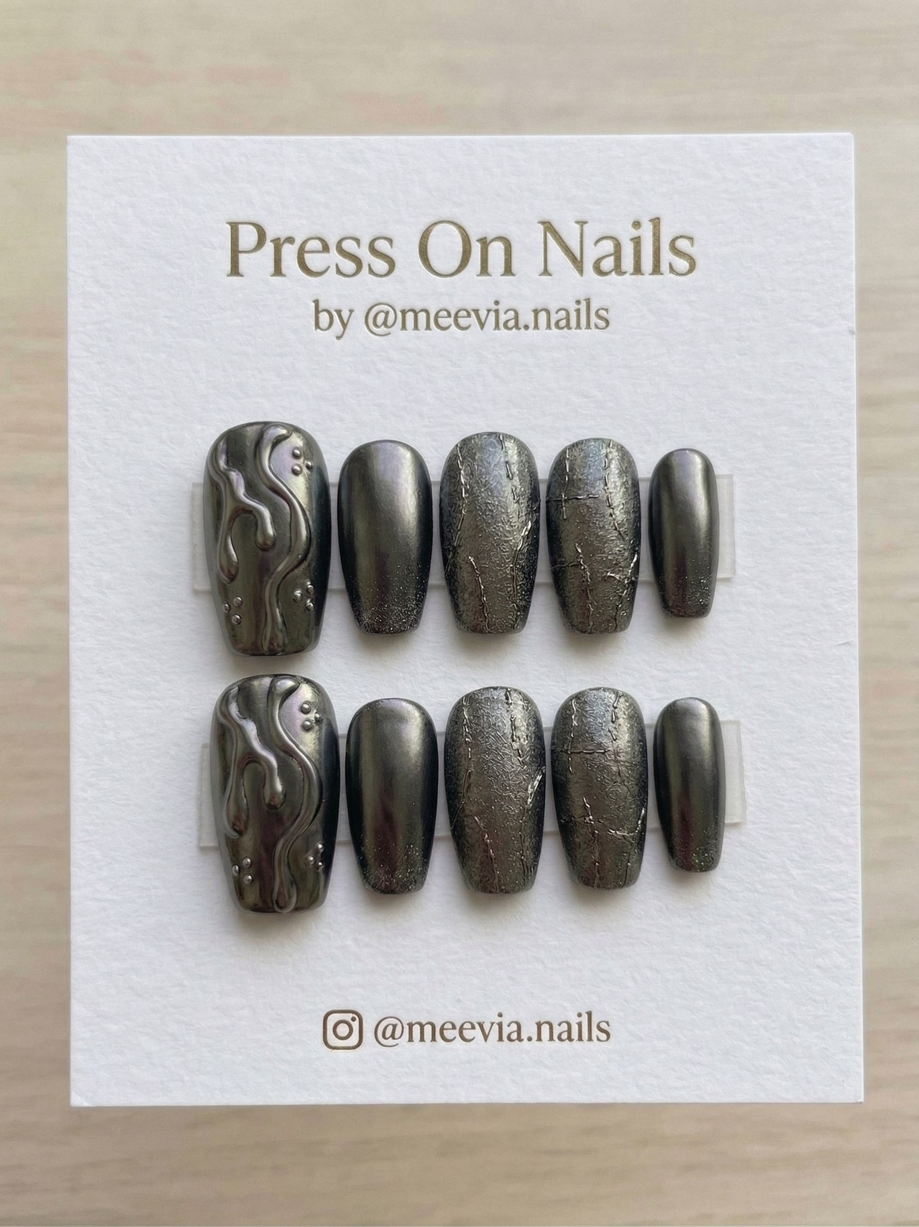 Coffin-shaped dark metallic press-on nail set with 3D molten waves and textured chrome finish