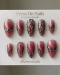 Stiletto-shaped pink cat-eye press-on nails with 3D silver chrome web patterns