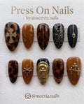 Long stiletto press-on nails with 3D silver webbing, black leopard print, and gothic lace designs.