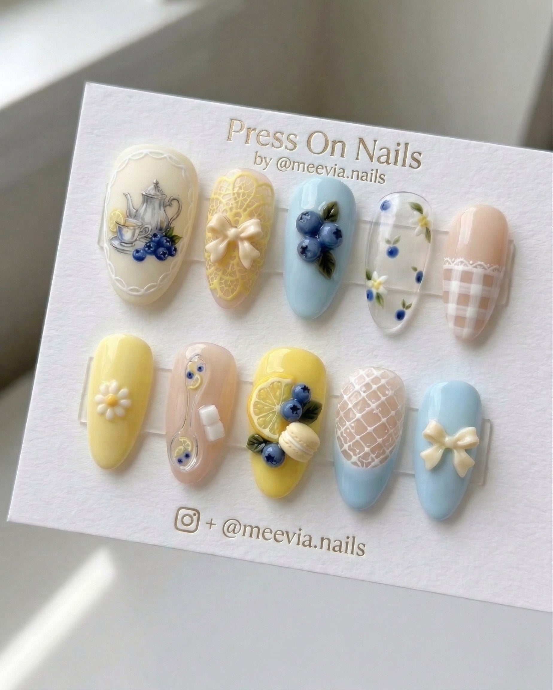 Oval-shaped blueberry and lemon tea party press-on nail set with 3D bows and fruit motifs.