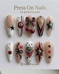 Almond-shaped press on nails featuring 8-ball, cherry, and bow 3D nail art in red, black, and white.