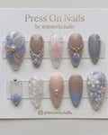 Almond-shaped press-on nail set with 3D floral art, pearls, and blue-lavender gradient