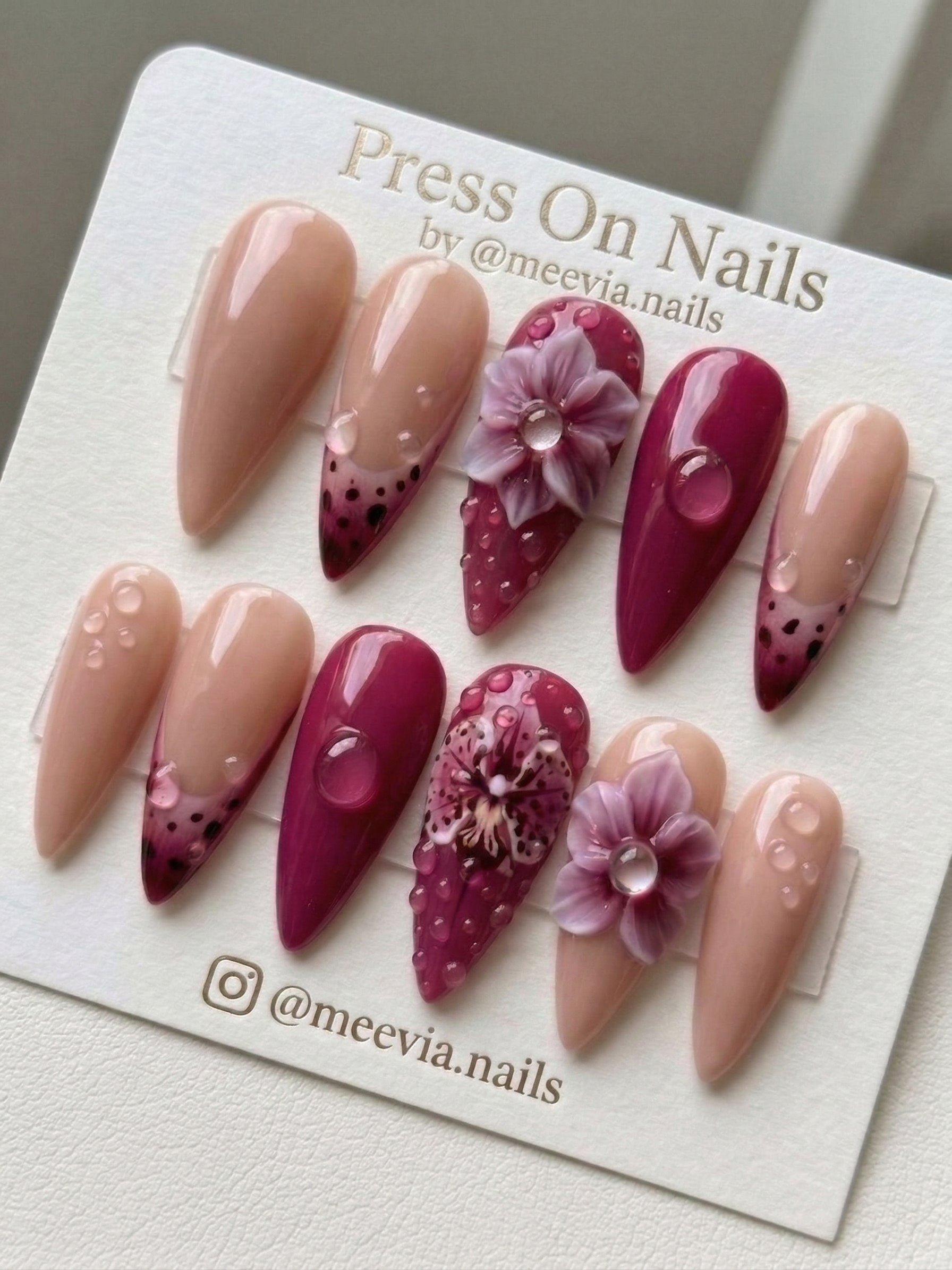 Stiletto-shaped berry pink and nude press-on nail set with 3D floral art and water drops