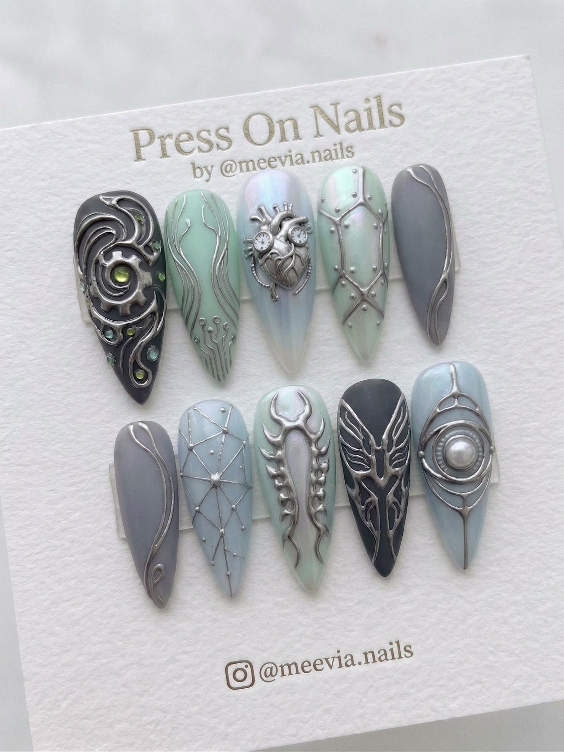 Stiletto-shaped steampunk press-on nails with silver 3D heart and gear motifs