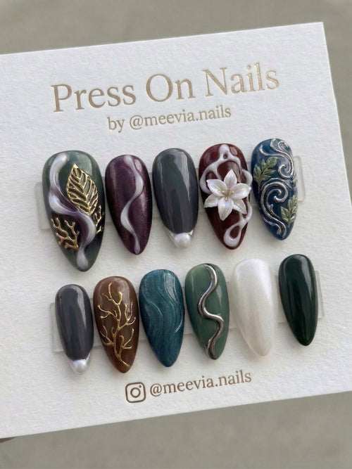 Almond-shaped press-on nail set with 3D floral and metallic gold leaf designs in deep jewel tones