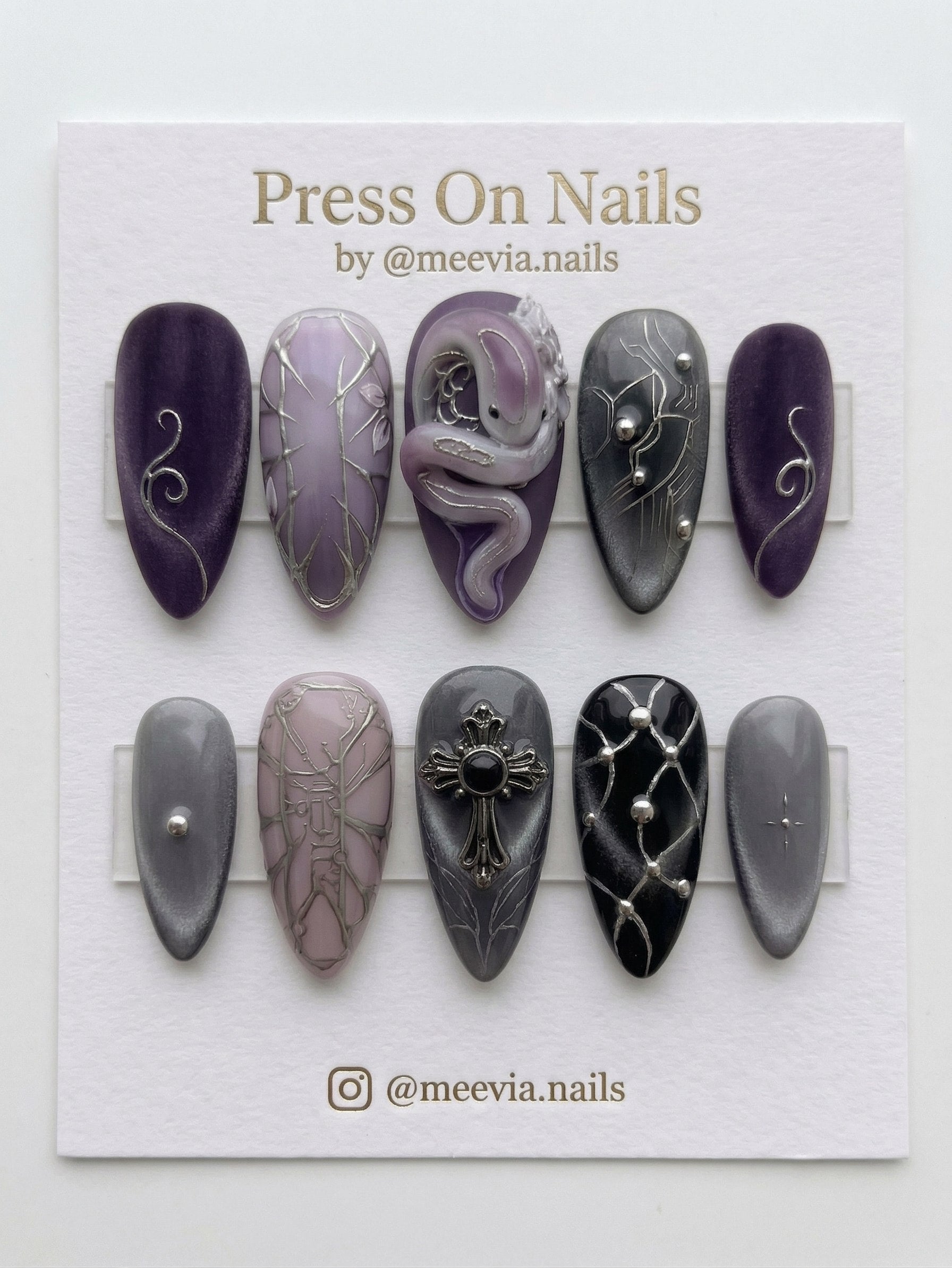 Almond-shaped purple and grey press on nails with 3D nail art snake and gothic cross details