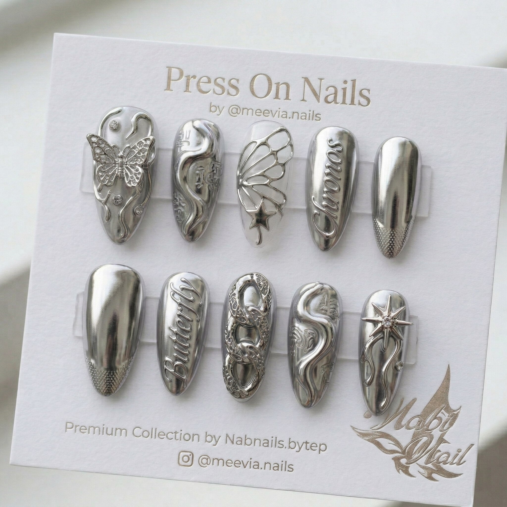 Almond-shaped purple press-on nails with 3D snake art, white flowers, and shimmer finish