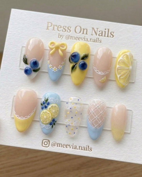 Almond-shaped press on nail set featuring 3D blueberry and lemon designs with yellow bows and lace art.
