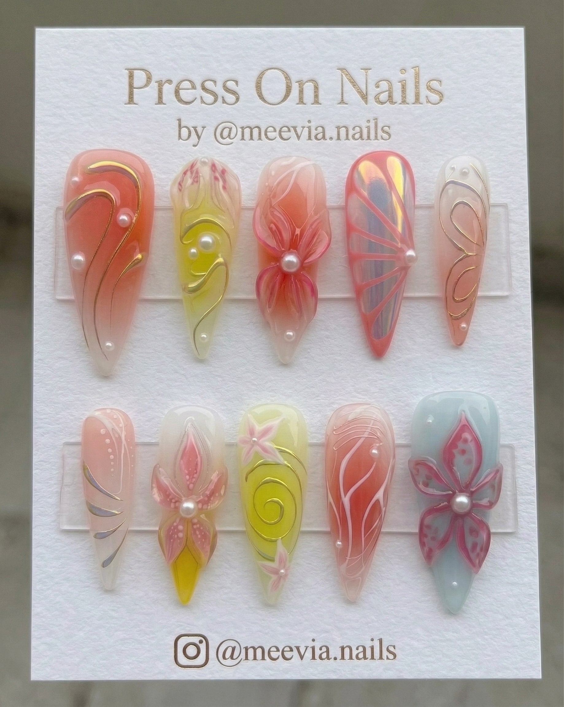 Stiletto-shaped 3D floral peach press-on nail set with pearl accents and shimmer finish