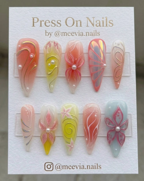 Stiletto-shaped 3D floral peach press-on nail set with pearl accents and shimmer finish