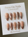 Almond-shaped press-on nail set with leopard print tips and rose gold shimmer finish