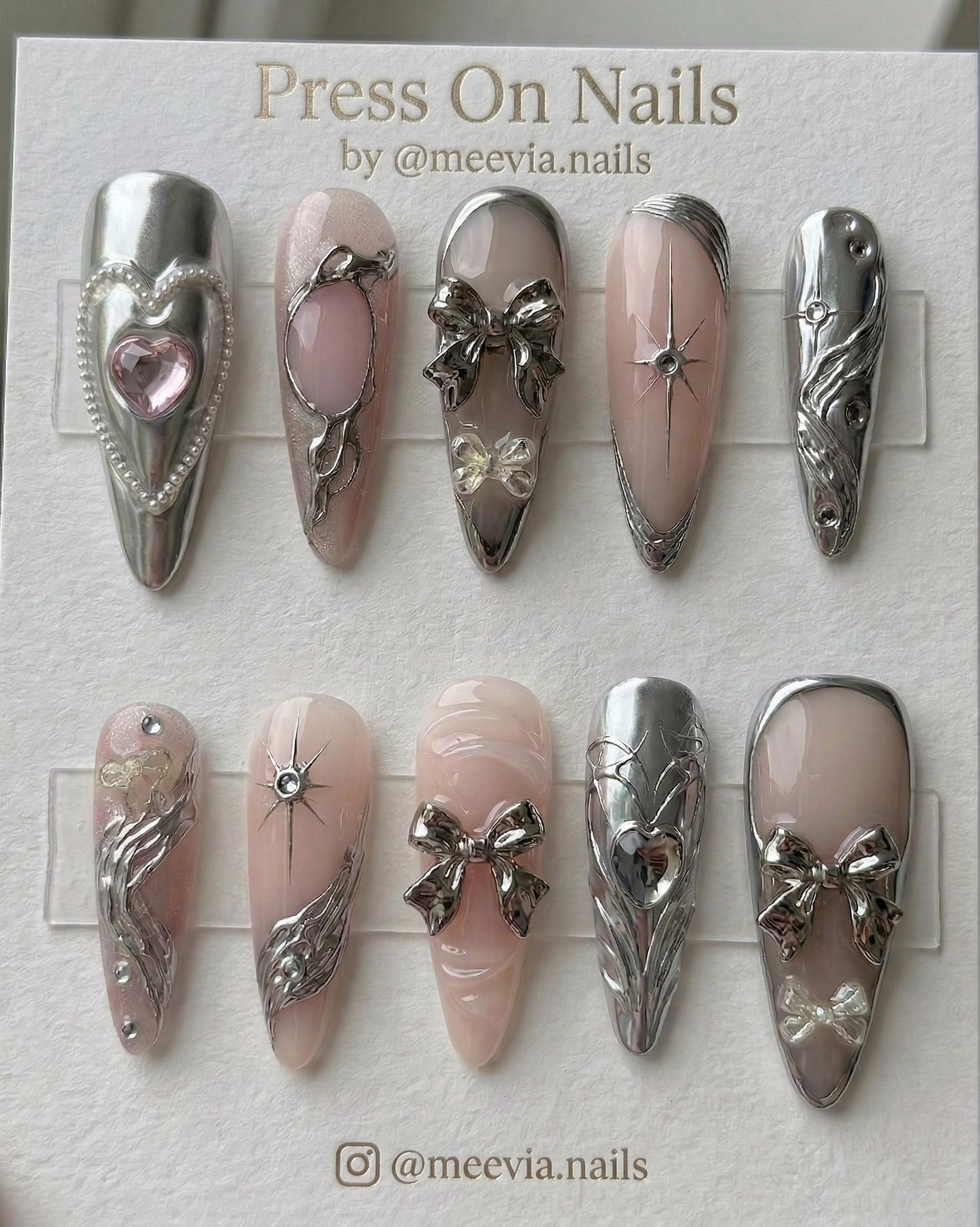 Stiletto-shaped silver chrome and pink press-on nail set with 3D bows and heart motifs