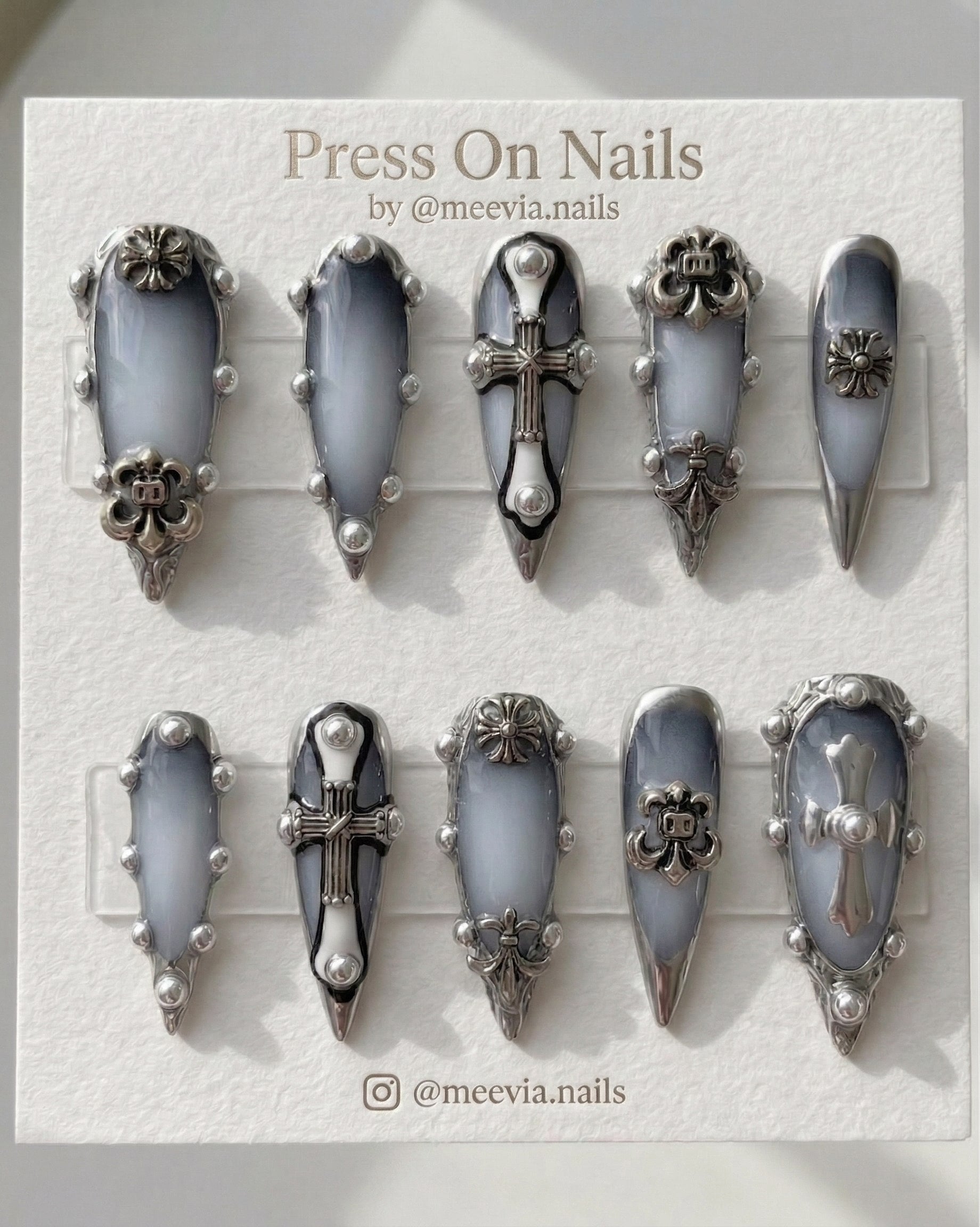 Stiletto-shaped gothic press on nails with smoky grey ombre and 3D silver chrome cross charms