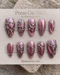 Almond-shaped purple press-on nails with 3D snake and white flower motifs