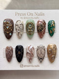 Almond-shaped press-on nails with leopard print tips, rose gold shimmer, and silver metallic accents.