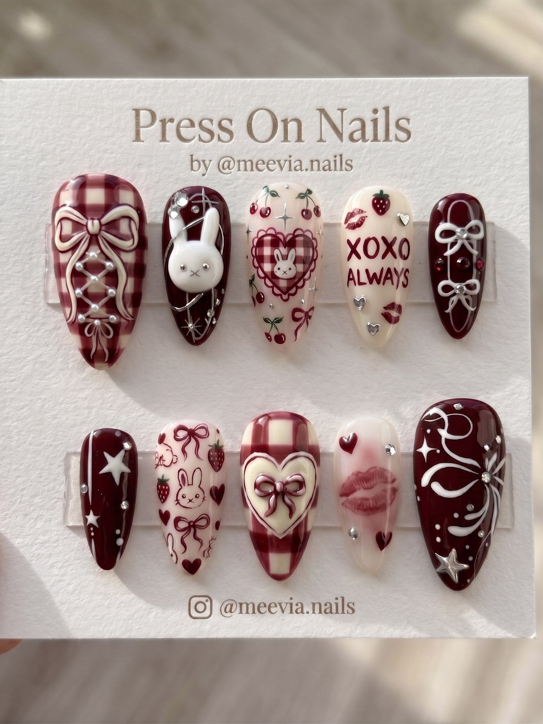 Stiletto-shaped black and white press-on nail set with 3D silver chrome accents and heart motifs.