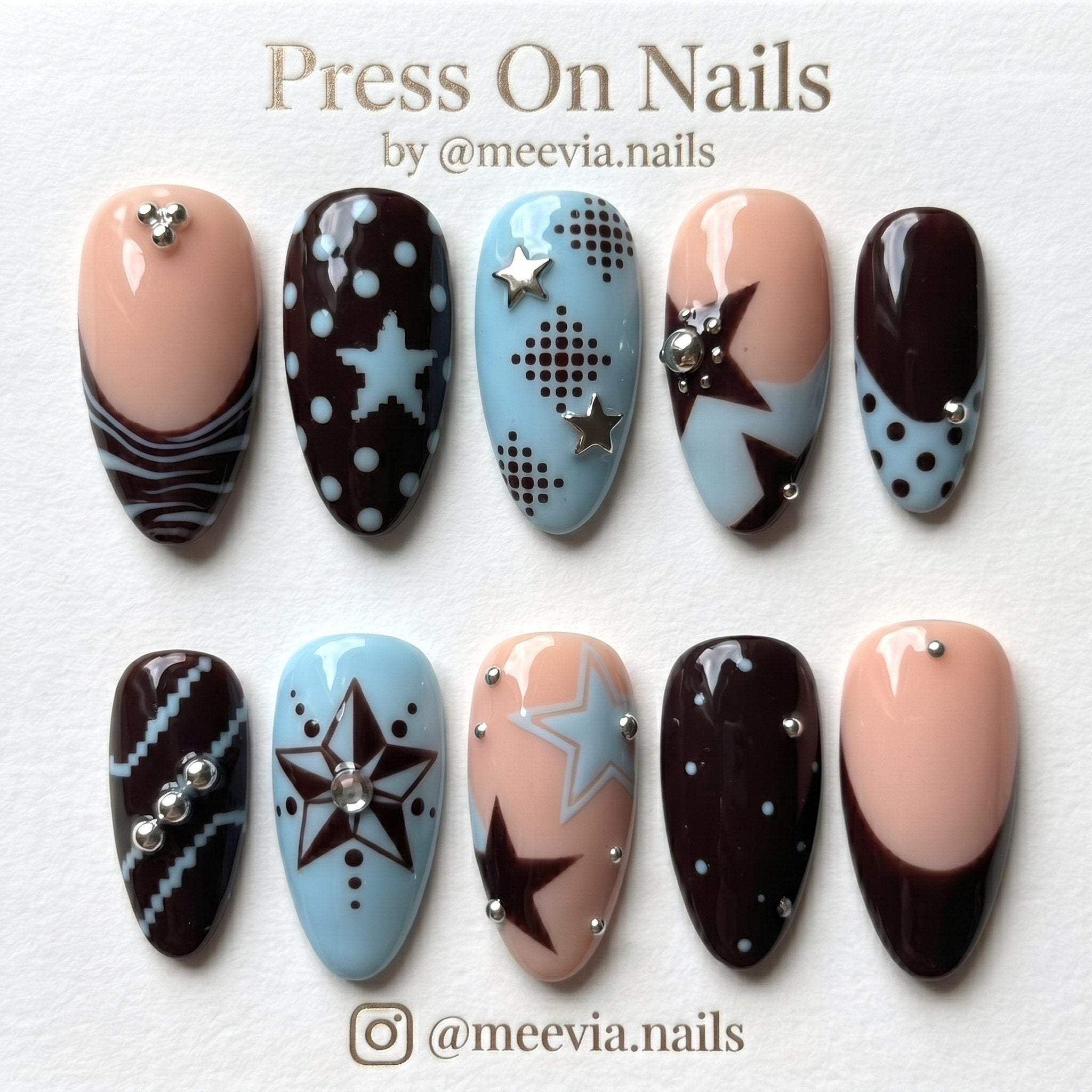 Almond-shaped mocha brown and light blue press-on nail set with star motifs and silver 3D nail art studs