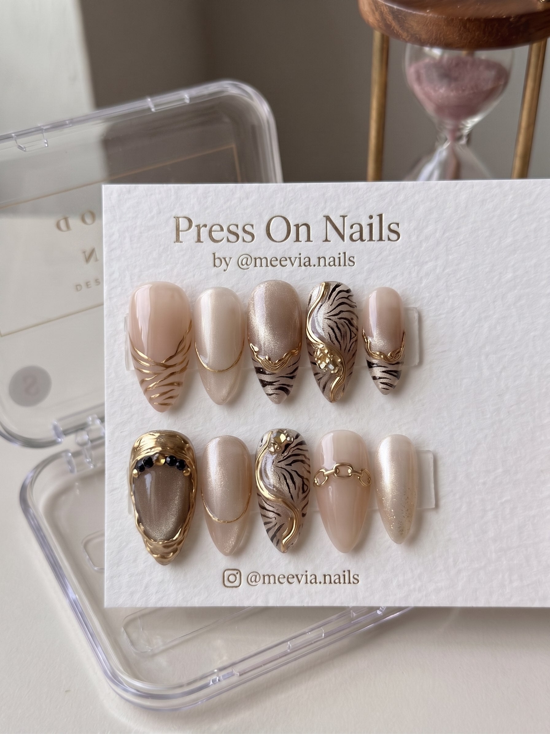 Almond-shaped gold tiger stripe press-on nail set with 3D accents and shimmer finish
