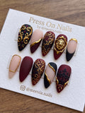 Stiletto burgundy and black matte press-on nail set with 3D gold baroque filigree and lion head accents