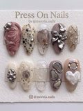 Almond-shaped press-on nail set featuring 3D metallic flowers, dried floral accents, and agate-inspired designs.