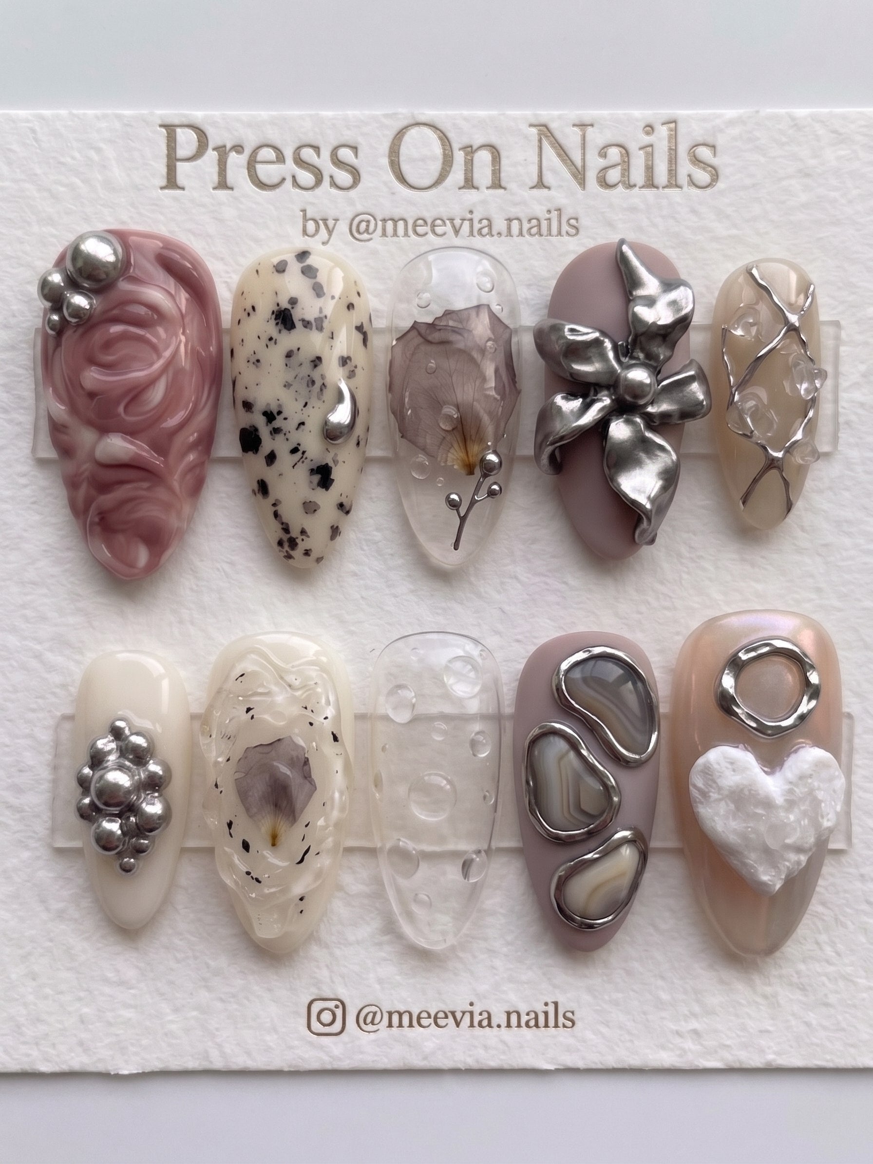 Almond-shaped press-on nail set featuring 3D metallic flowers, dried floral accents, and agate-inspired designs.