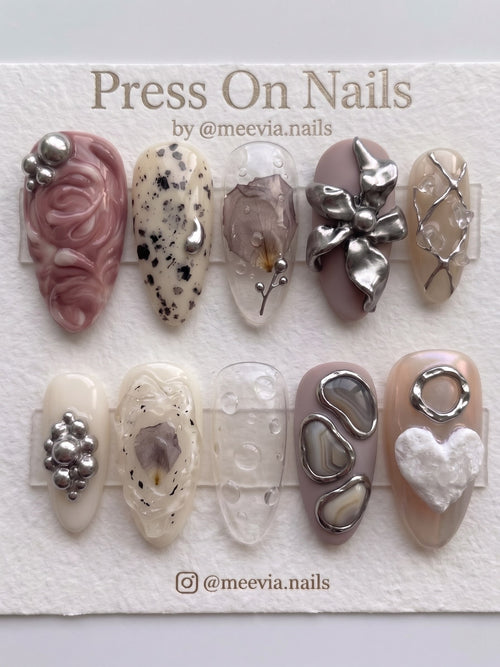 Almond-shaped press-on nail set featuring 3D metallic flowers, dried floral accents, and agate-inspired designs.