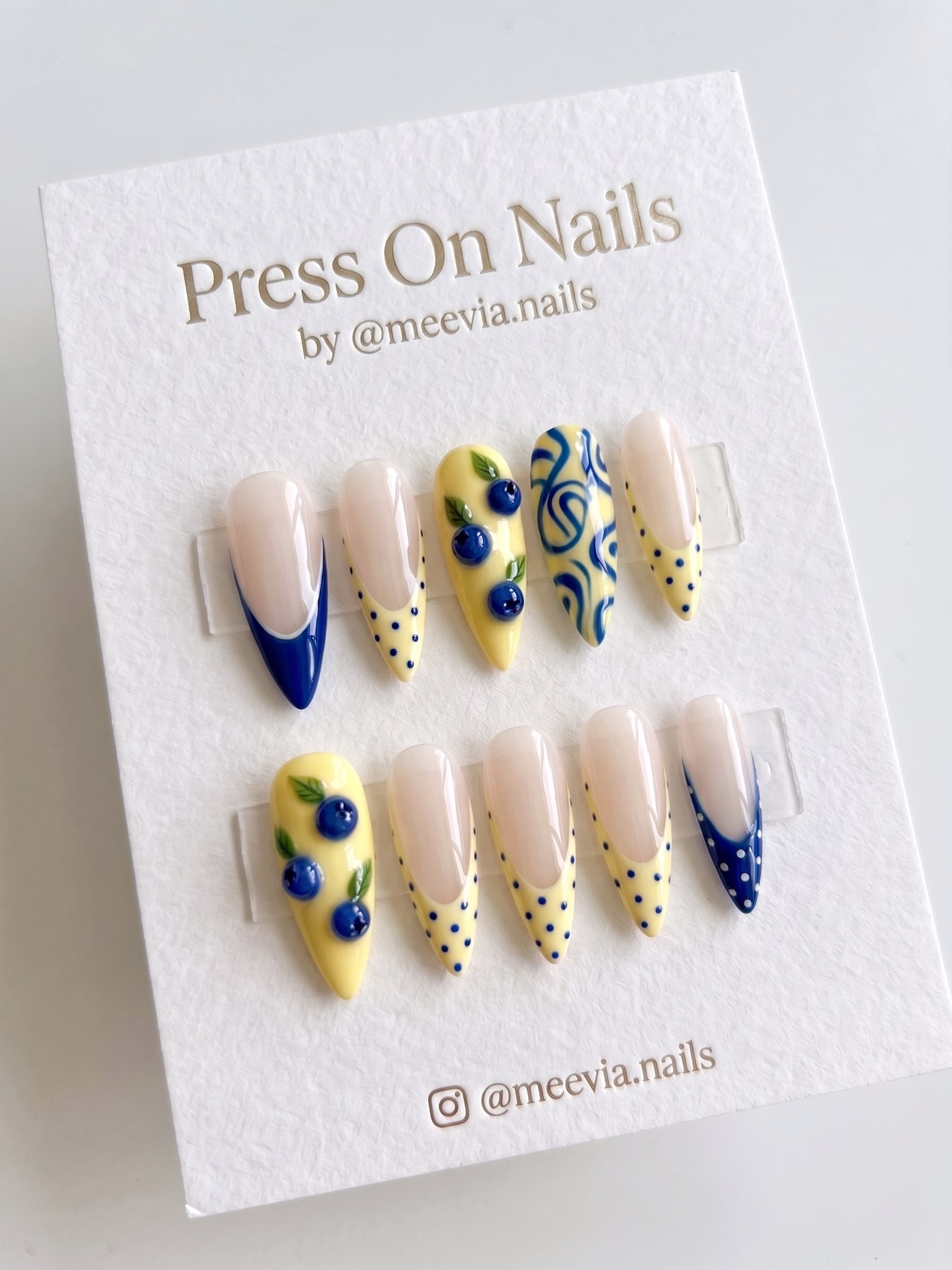 Almond-shaped press on nails with yellow and blue blueberry 3D nail art and French tips